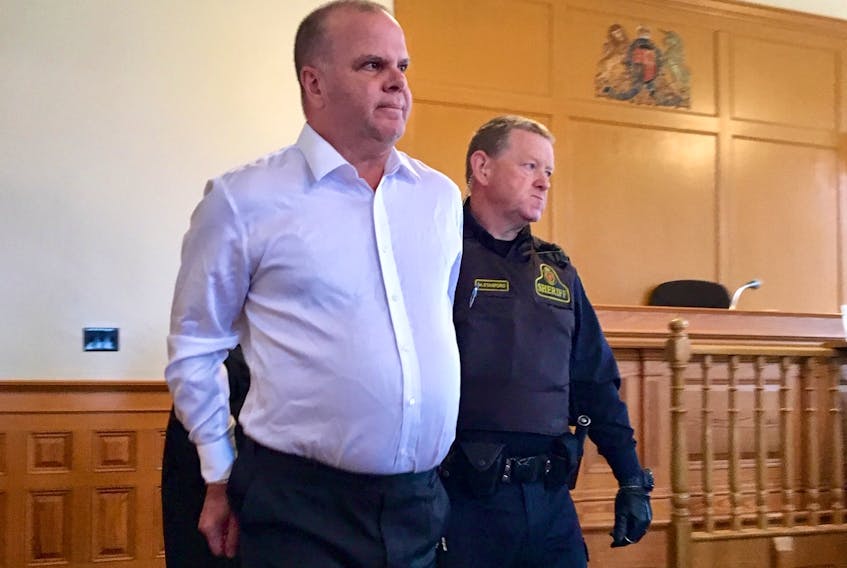 Mark Rumboldt — who was found not guilty Saturday of attempted murder, but guilty of administering a noxious substance to his wife — is led in to Newfoundland and Labrador Supreme Court in St. John's Tuesday to set a date for his sentencing hearing.