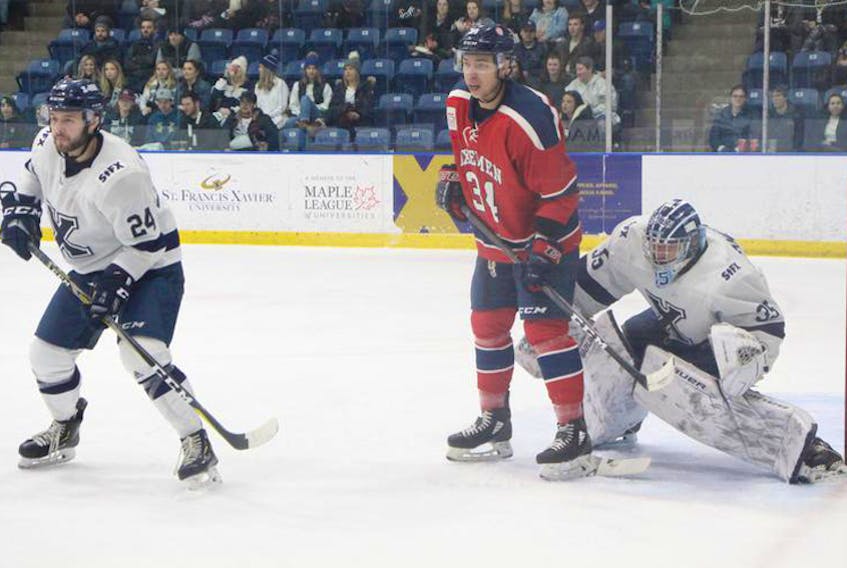 St. Francis Xavier X-Men goalie Chase Marchand tries to see past the screen by Acadia Axemen’s Stephen Harper during Game 1 of the AUS quarter-final on Wednesday night in Antigonish. St. F.X.’s Daniel Robertson watches the play. - Richard MacKenzie
