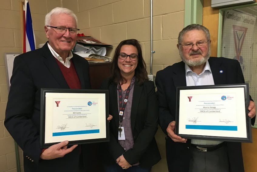 Cumberland YMCA CEO Trina Clarke presents Peace Medals to former Cumberland-Colchester MP Bill Casey (left) and retired Amherst lawyer and longtime Amherst Rotary Club member Morris Haugg on Nov. 20.