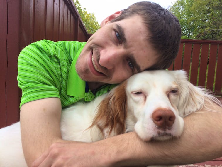 Colin Hanames, 28, of St. John's, with his pet dog Babe, a five-year-old Brittany Spaniel that he reached three years ago. Babe was in his car that was stolen Monday afternoon and flipped over in Tors Cove later in the evening.