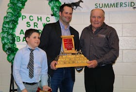 George Riley, on the right, presents Marc Campbell, standing with one of his sons, Landon, the Horseman of the Year Award.