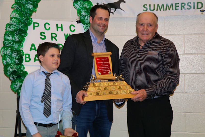 George Riley, on the right, presents Marc Campbell, standing with one of his sons, Landon, the Horseman of the Year Award.