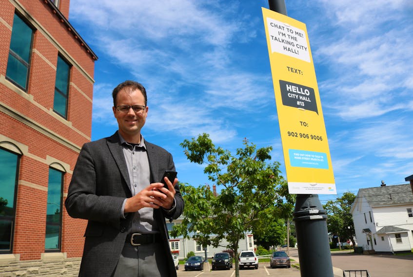 Neil Moore, a research analyst with the economic development department with the City of Summerside, texts city hall's talking lampost to learn more about the city.