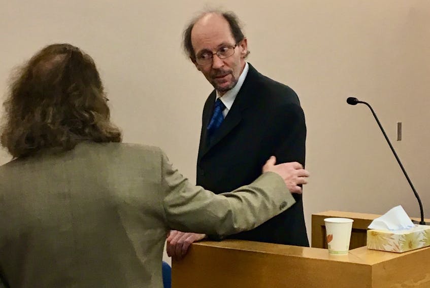 Kenneth Harrison (right) speaks with his lawyer Bob Buckingham during his trial Friday at provincial court in St. John's. Harrison collapsed on the stand during his testimony.