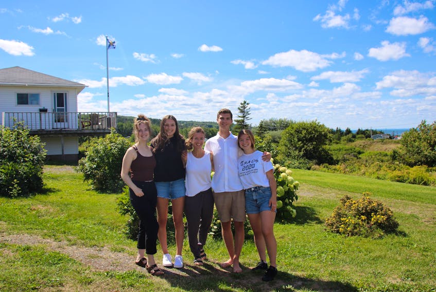 Returning St. Francis Xavier University students Kate D’Albertanson, Erika Kiehlbauch,Blaise D’Albertanson and Keira Ross with their chaperone Lynn D'Albertanson (centre) at the family cottage in Arisaig, Antigonish County, where they are self isolating. (CONTRIBUTED PHOTO)