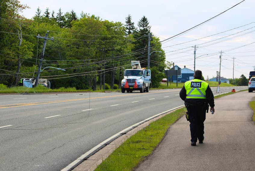 An investigating officer walks towards the scene of an accident this morning on Grand Lake Road.