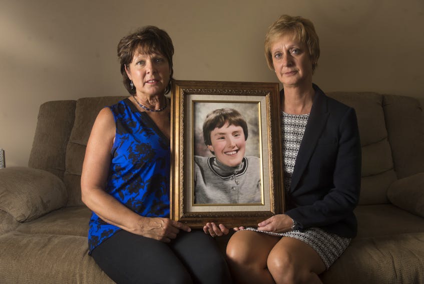 Elizabeth Deveau and Dorothy Dunnington hold a photo of their sister Chrissy who died earlier this year from an infected bedsore.