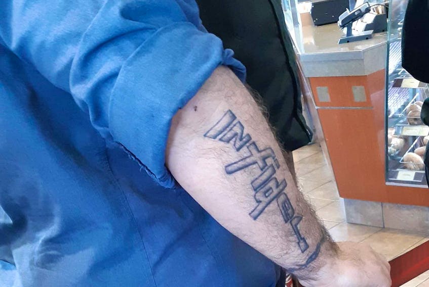 The Royal Canadian Navy is looking to identify a sailor with the word infidel tattooed in the shape of a rifle on his arm.
