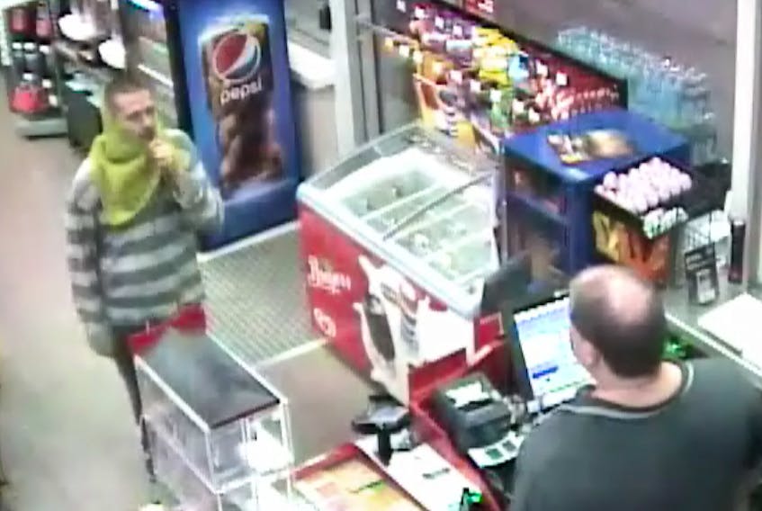 This camera footage shows the subject in a robbery of the Circle K in North Sydney on Wednesday morning. The suspect was wearing grey jogging pants and a black/grey striped hooded shirt with a piece of green material around his head and neck. According to police, he also had very short dark hair and a moustache.