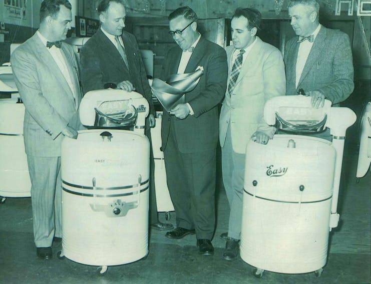 Irving Schwartz of Schwartz Furniture (fourth from left) in 1955 getting a demonstration on the new wringable washing machines.