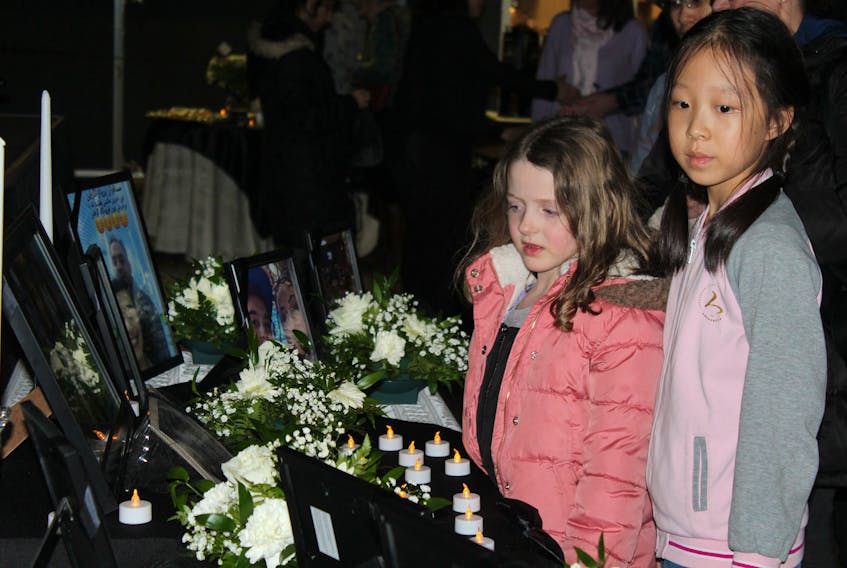 Rachel Xue, right, and a friend pay their respects at  a vigil service hosted by the UPEI Chaplaincy Centre, the UPEI Iranian Society and members of Persian community of P.E.I. on Monday at the  Murphy Student Centre. The vigil was organized to honour the victims of the recent Ukraine Airlines plane crash in Iran that killed 176 passengers, including 63 Canadians. Ernesto Carranza/The Guardian