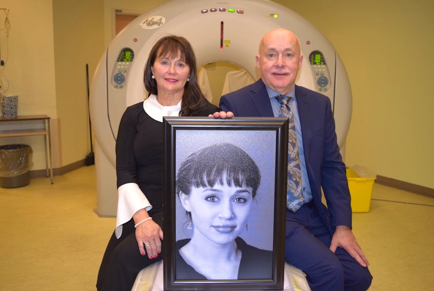 Jenna Delaney’s parents Jean and Brian pose with a picture of their daughter, next to the CT scanner in need of replacing at the Colchester East Hants Health Centre on Oct. 20. Her parents paid a tearful tribute to their 20-year-old daughter, who passed away from cancer in 2007. Her diagnosis was held up for several months by broken equipment, later prompting her family to make a gift to the CEHHC towards purchasing new machinery, including the CT scanner seen here.