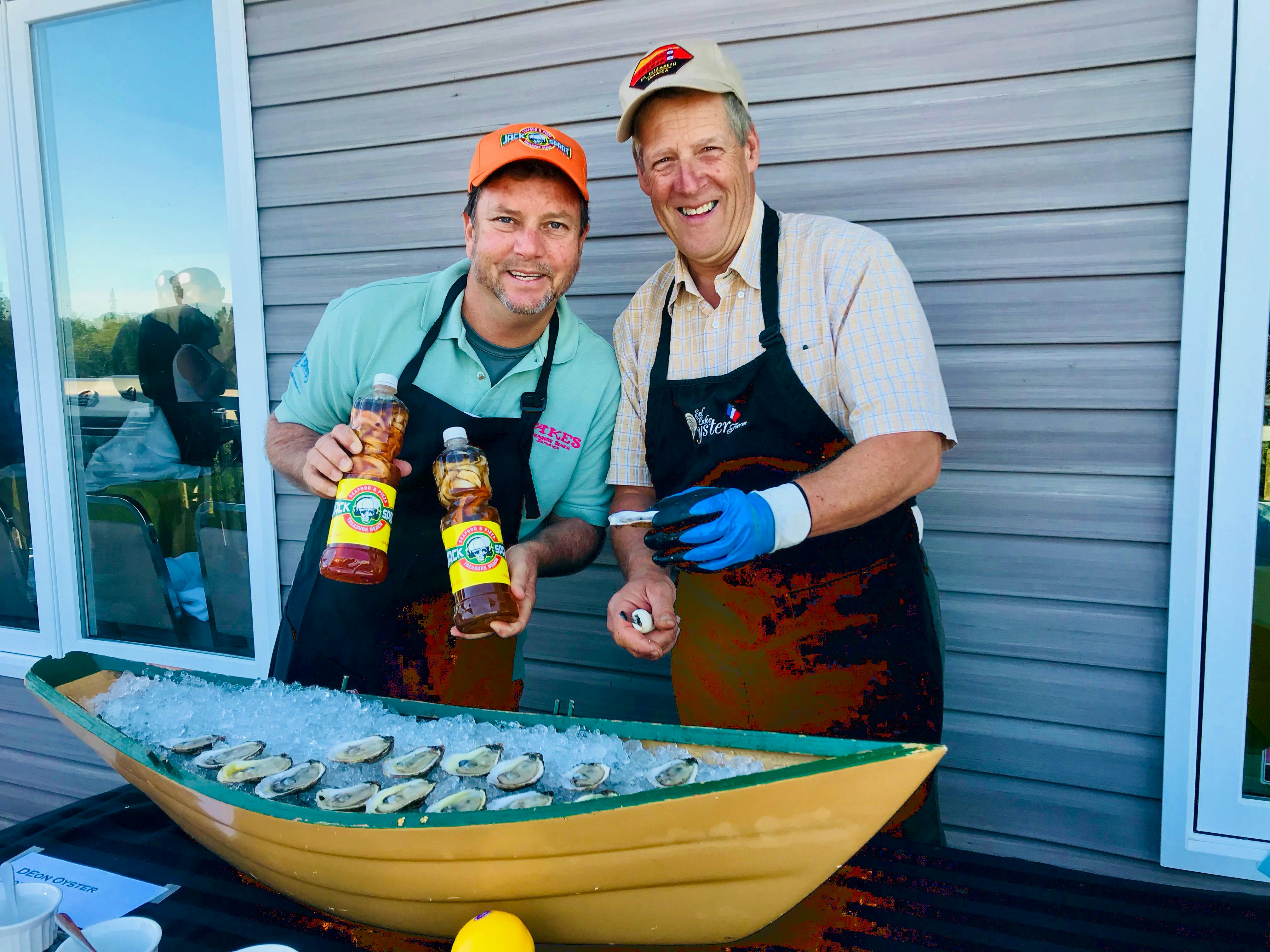 Jason Henzell, left, and Nolan D’Eon serve up fresh oysters from DEon Oyster Company in Eel Lake, Yarmouth County, with Henzell’s sweet or sour oyster sauce, at an event at the West Pubnico Golf & Country Club, hosted as part of the Yarmouth Seafood and Wine Extravaganza with a Jamaican twist. Henzell owns restaurants and a resort in Jamaica.