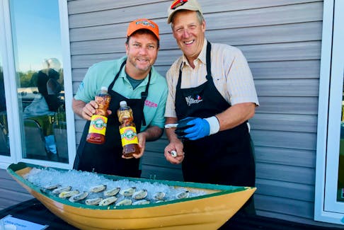 Jason Henzell, left, and Nolan D’Eon serve up fresh oysters from DEon Oyster Company in Eel Lake, Yarmouth County, with Henzell’s sweet or sour oyster sauce, at an event at the West Pubnico Golf & Country Club, hosted as part of the Yarmouth Seafood and Wine Extravaganza with a Jamaican twist. Henzell owns restaurants and a resort in Jamaica.