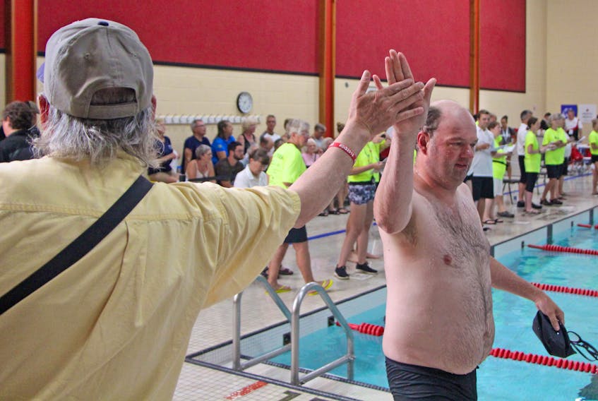 Wes Bradford gives a high-five to his son, Jess Hansen, a swimmer with Team B.C., after completing an event Friday morning at St. F.X.’s Alumni Aquatic Centre during the Special Olympics Canada 2018 Summer Games in Antigonish. Corey LeBlanc