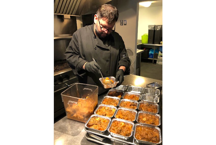 John Pritchard dishes out some of the 100 meals that will be distributed to children, at home, during the COVID-19 crisis. Pritchard operates Pure Kitchen in Charlottetown. 