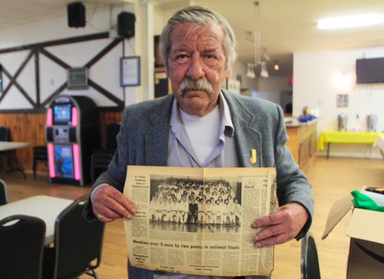 Instructor Wayne Reynolds holds up an old newspaper photo of Port Hawkesbury Judo Club members, following a celebration of the club’s golden anniversary June 22.