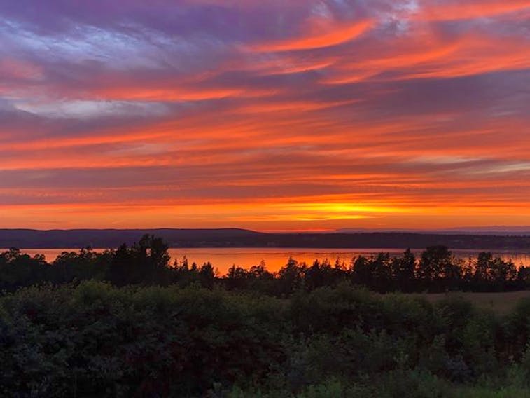 Sunset photos can be a little bit like rainbows- somewhat unique to the observer’s eye. 
This is what Monday evening’s offerings looked like in Point Edward, on Cape Breton Island.
Peter John Hill captured this incredible display of crimsons in the western sky.  Red sky at night…