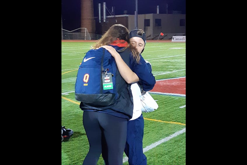 Anna and Lucy Killacky, sisters, hug it out on the field after they played against each other on rugby teams with Queens University and St. Francis Xavier University, respectively. Their father, Chris, worked at Acadia and cheered both on during the match.