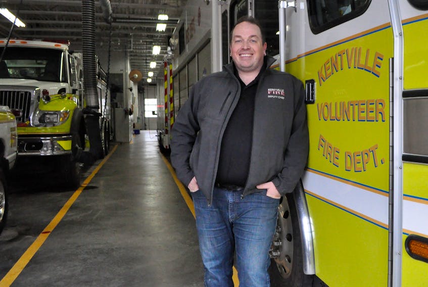 Second deputy fire chief Scott Hamilton stands with the firetrucks in the bay area of the department. He and other department members will be at the Feb. 28 area rate meeting, held at 7 p.m. inside the hall's auditorium.
