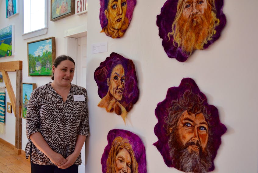 Artist Tacha Reed next to her latest project, Stewards, fibre portraits of Hants County artists and activists at the Avon River Heritage Society Museum During the 21st annual Great Little Art Show, which wrapped up on May 26.