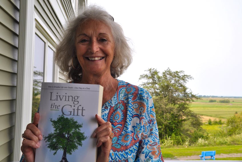 Pauline Murray holds ‘Living the Gift,’ a book she produced from her late husband Charles’ personal blog about his experience living with ALS, also known as Lou Gehrig’s Disease. Charles passed away in 2015.