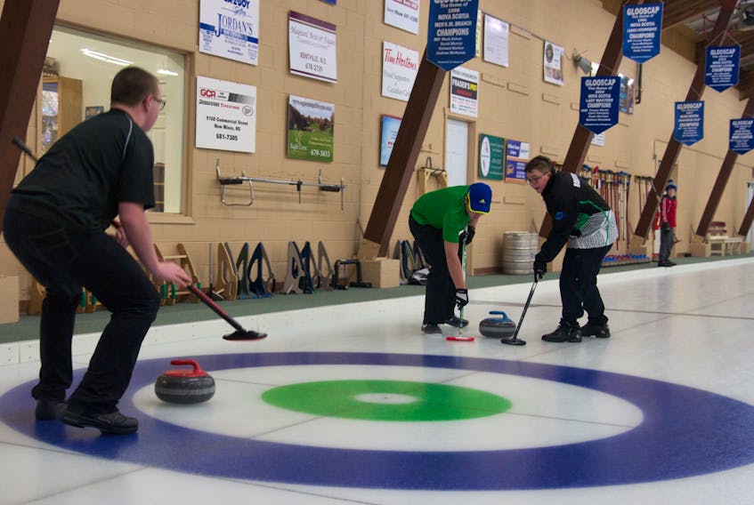 A team of U14 curlers sweep as the rock makes its way down the ice at the eighth annual Earl MacKinnon Classic Jan. 21 at the Glooscap Curling Club in Kentville.