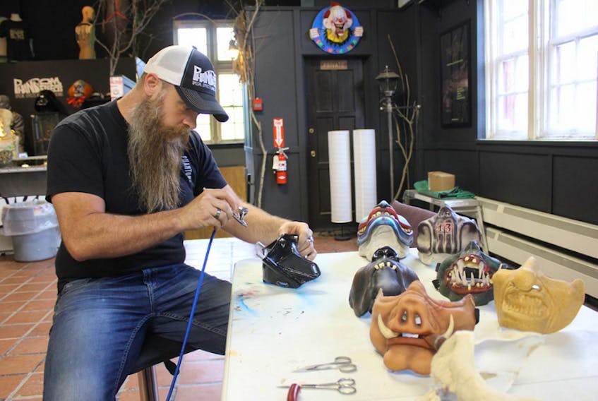 Aaron Peerless of Phantom FX works with a Darth Vader-style motorcycle mask in his Kentville shop. Peerless started making protective masks a few years ago after twice being hit in the face by a bee while riding.