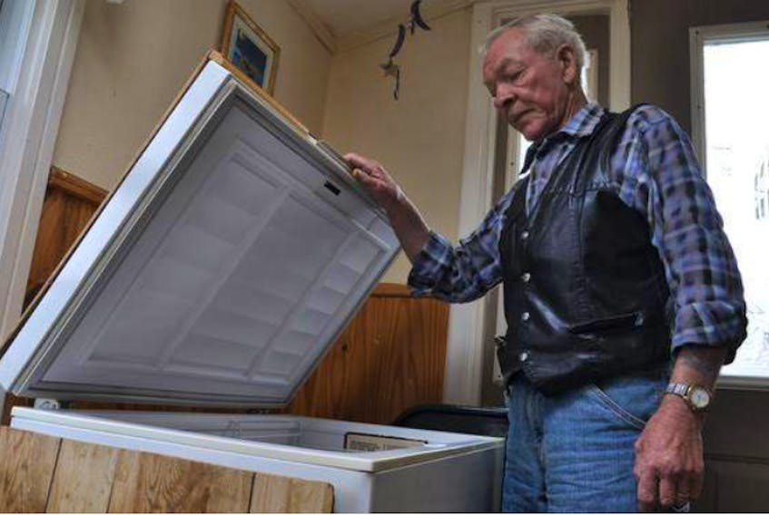 Rodney Humphery stands by the freezer where his wife Marian had stored the chicken burgers for the Public Health Agency of Canada for testing until they were picked up June 1 – the day before a recall was issued.