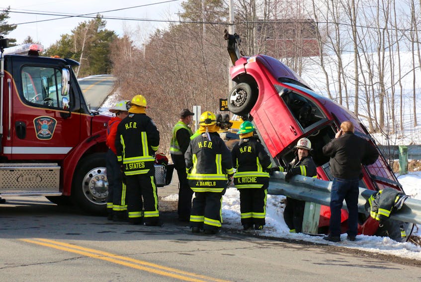 Hantsport firefighters watch as work gets underway to pull the vehicle out of the ditch. The driver had to be extricated and was treated by paramedics for minor injuries April 10.