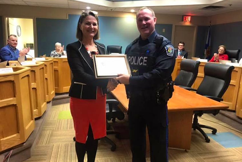Kentville Mayor Sandra Snow presents Kentville Police Service (KPS) Const. Kevin Lutz with a plaque of recognition after he found and put out a garage fire. KPS chief Julia Cecchetto confirmed that had Lutz not put it out in time, “without question, it would have ended up a full structure fire.”
