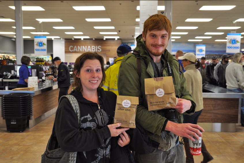 Ashley Zinck and Keegan Penney smile as they hold their first purchase of legal cannabis from the NSLC in New Minas. “It’s all pretty amazing – let’s just say it’s been a long time coming,” said Penney.