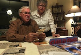 Earle and Betty Fuller comb through missing person posters and newspaper clippings relating to the disappearance of their youngest son, Lyndon Fuller, on Nov. 25, 1988.