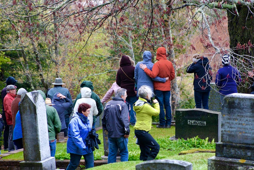 Participants at a recent Oak Grove Cemetery walk huddled together to keep warm as winds swept through the cemetery.
