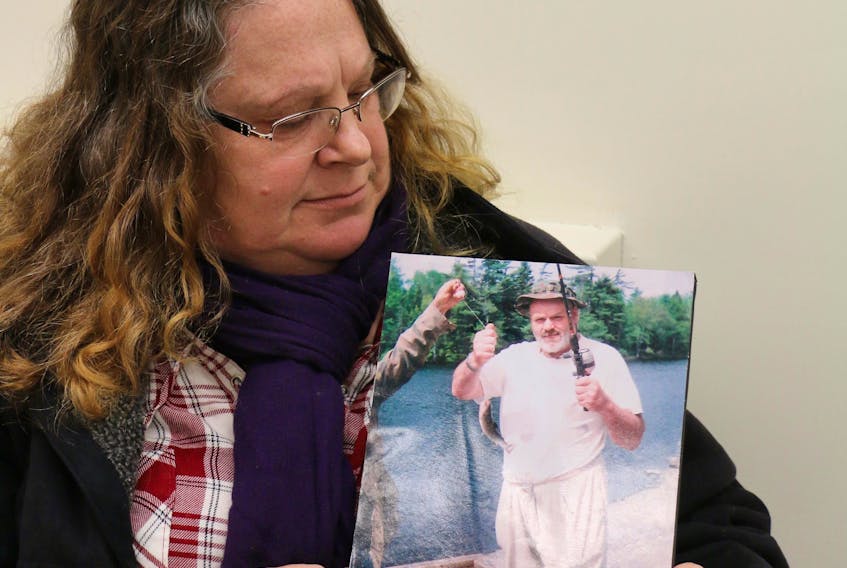 Vivian Wells looks at a photo of her brother, Tim Wells, who has been missing since May 2018. She's still grappling with his disappearance as the siblings were quite close.