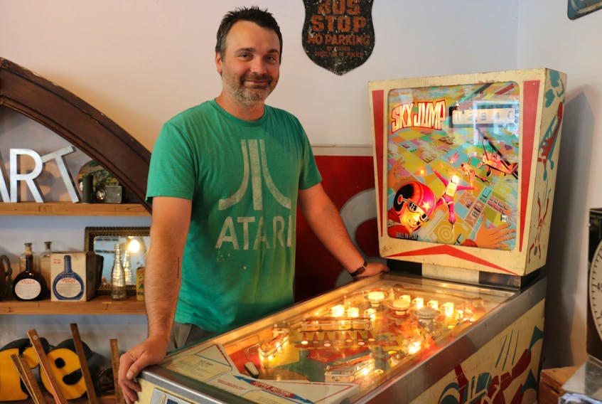 Conrad Mullins, owner and operator of Retrouve in Windsor, stands beside a Sky Jump pinball machine from 1974 ‚ one of the fun gadgets from yesteryear that he has for sale.