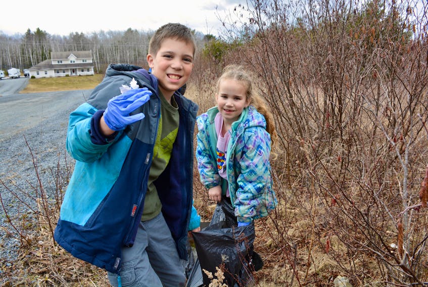Brother and sister Bradon Kelly, 10, and Coralee, 8, pick up some garbage at the Mount Uniacke Public Library on April 19, 2018 leading up to Earth Day.