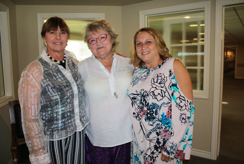 Cate Smith, centre, represents the 100 Women who Care Annapolis Valley, as the organization met June 21 to hear from three community programs. Leslie Porter, right, and Anne Parks represented the evening's successful presenting group, the Windsor Senior Citizens Bus Society.