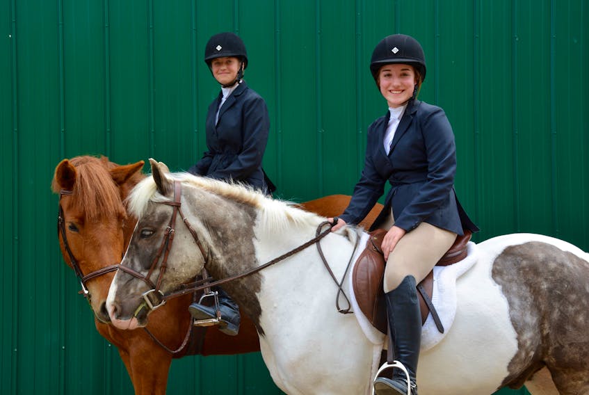 Dakota MacDonald, 14 with her horse Beauty (left) and Dara Rossong, 13, with her horse Gucci get ready to participate in the 2018 Mega Training Show.