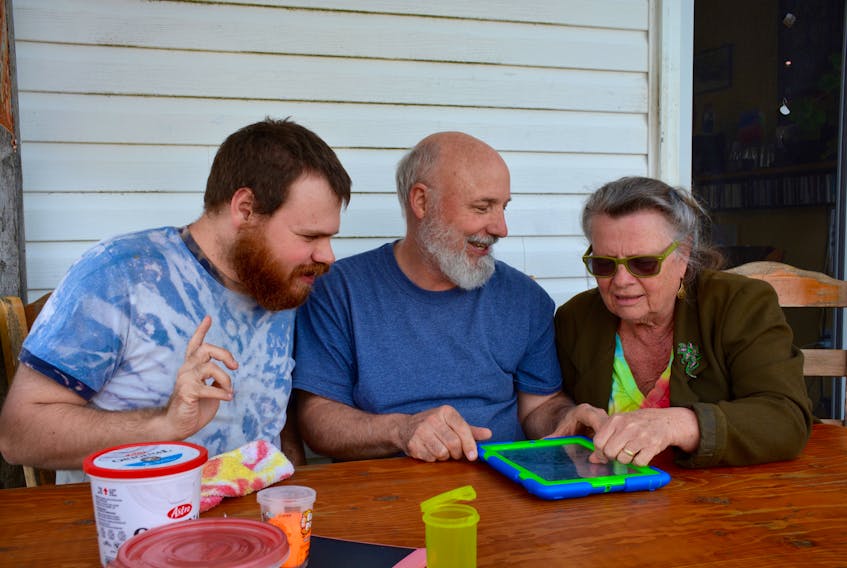 Kimberly Smith, Kathleen Purdy and their son, Brendon Purdy-Smith, play with apps on an iPad at their home in Canning.