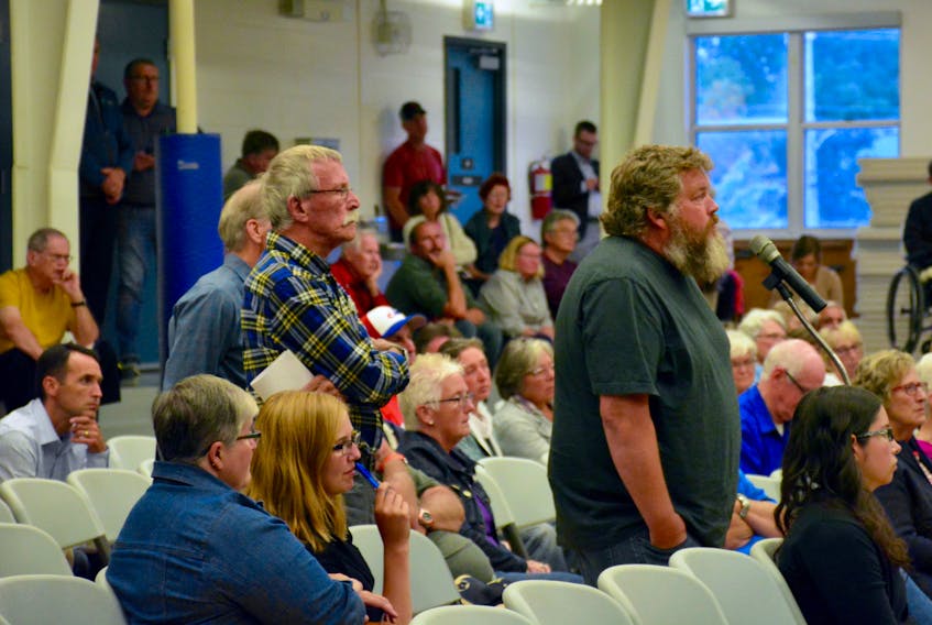 Community residents Darren Porter (right) and Bill Preston line up to ask questions during a public meeting on the Halfway River aboiteau on Sept. 10.