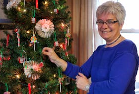 Karen Price, of Lockhartville Road, hangs a handmade ribbon candy ornament on the tree. She's found great success in creating these clay ornaments this year. CAROLE MORRIS-UNDERHILL