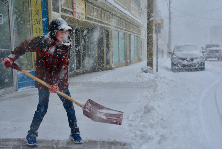 Raymond Hart, 12, shovels the entryway in front of Hopper’s Jewellers in Windsor, NS, during a Nor’Easter on March 22, 2018.