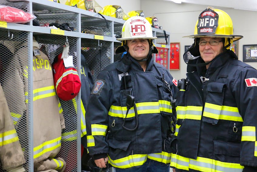 Hantsport deputy fire chief Paul Maynard and driver Dave Miller pose by the new dressing area. The bunker gear was moved to the inside of the station in response to the safety concerns associated with keeping it in the bay with the trucks.