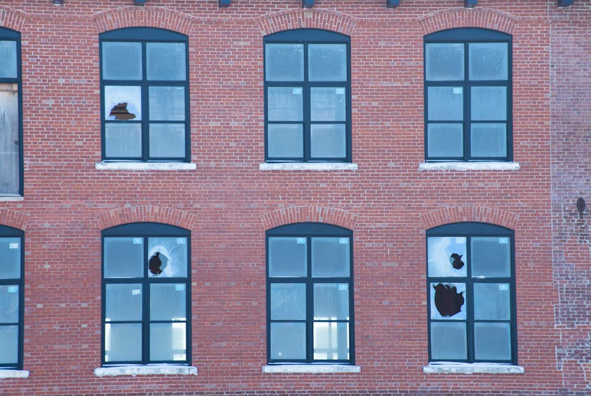 Damaged windows are visible from the outside of the former Nova Scotia Textiles building in Windsor.