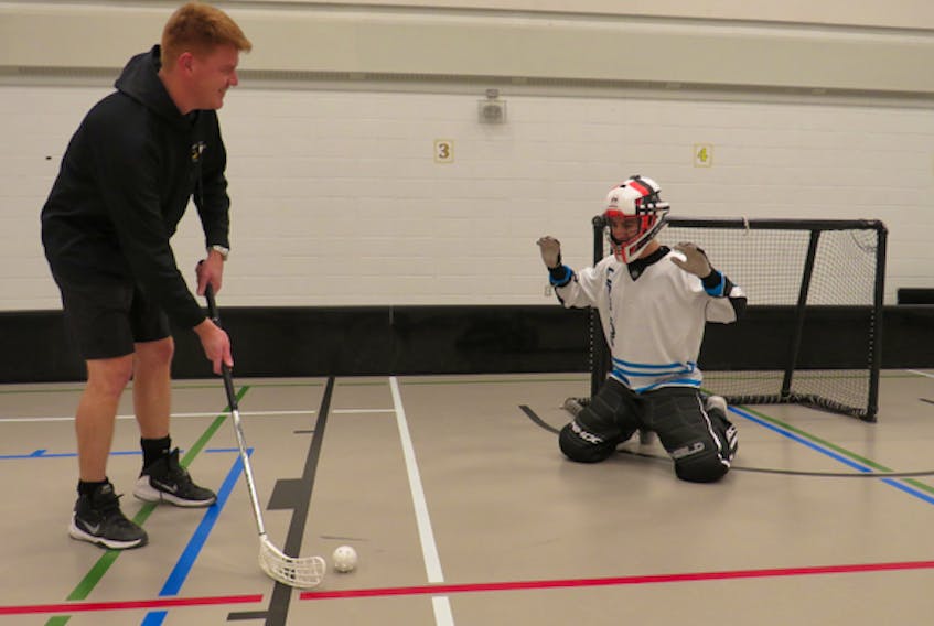 Coach Steve Broome, right, challenges goalie Simon Tracy during a practice at Wolfville School recently.