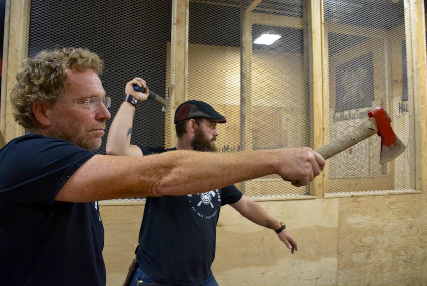 Fred Ansems, left, and Steve Rex both give their favourite axes a throw at HaliMac Axe Throwing in Kentville.