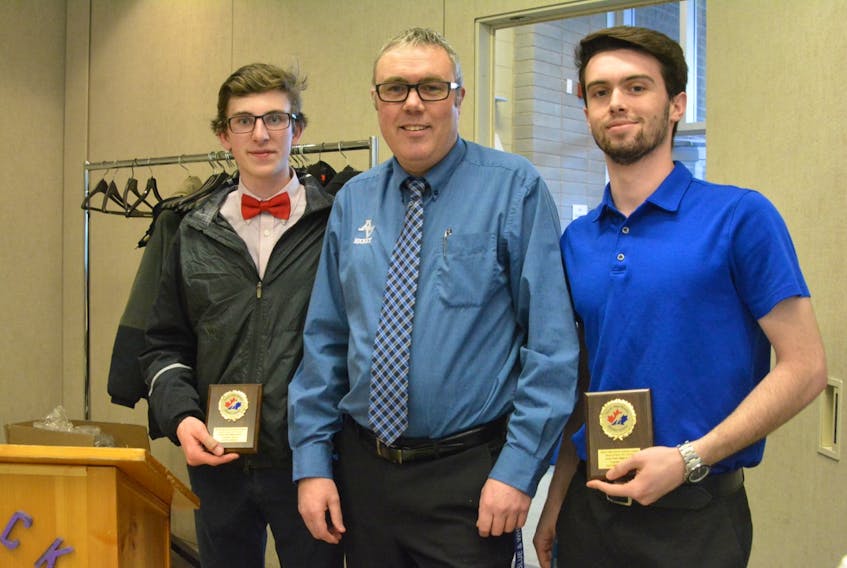 Liam Parker (left), 17, and Jacob Caldwell, 17, accept their coach’s award from Mark Tye during the Valley High School Hockey League banquet at the Berwick Lions Club on April 5, 2018.
