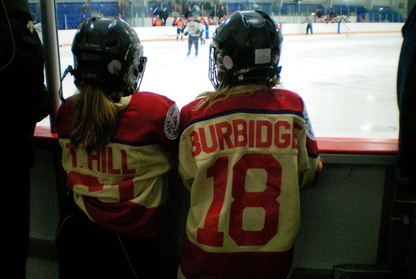 Tiffany Hill and Maggy Burbidge, seen watching hockey together when they were much younger. Their bond through hockey is strong as they approach the 2017 U18 National Tournament in Quebec.
