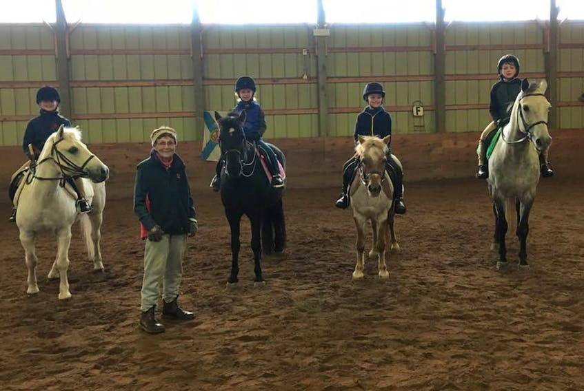 Pony Clubbers, and their ponies, recently posed for a photo with Avon Pony Club founder and instructor, Mary Henry.